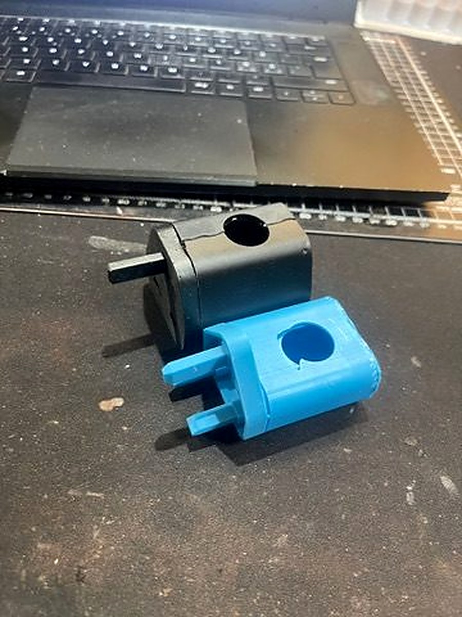 Two 3D-printed Charlie Charger prototypes — SLA black and FDM blue — showing design iteration