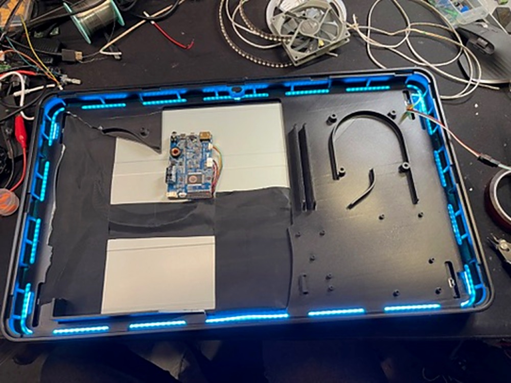Genboard back panel open showing Radxa SBC mounted with blue RGB LED strips illuminated